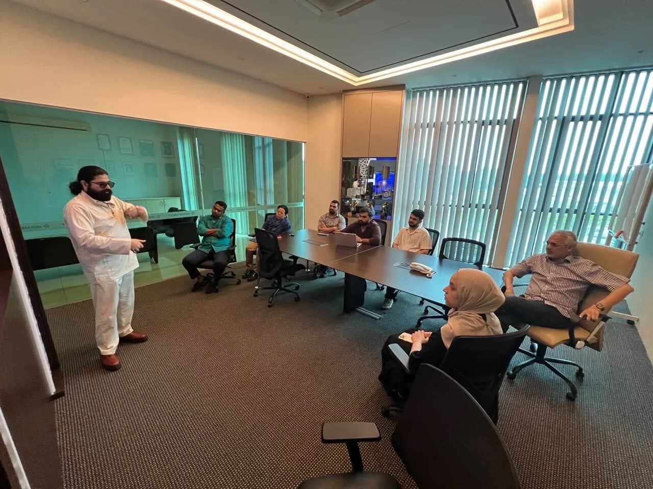 A member of the Watson team presenting to the room at AlShaik Group's headquarters, with others seated along the boardroom table.